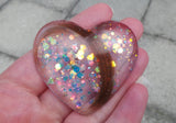 Lock of hair keepsake, baby's first curl, ecopoxy resin palm stone heart with a choice of opal glitters